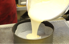小麦粉、生クリームなど材料を入れてよく混ぜたら型に流し込みます。この後クルミを投入して更にチョコレート生地。